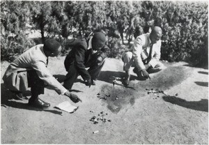 Three witch doctors consulting their ossicles