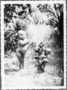 A toddler playing at a fountain, Lutindi, Tanzania, ca.1927-1938