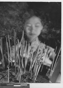 A woman burning incense in China