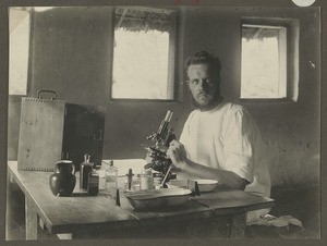 Mission deacon Nüßler using microscope, Tanzania, ca.1929-1940