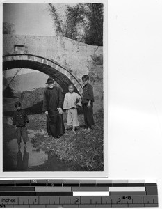 Fr. Maurice Ahern with children by a river at Meixien, China, ca.1929