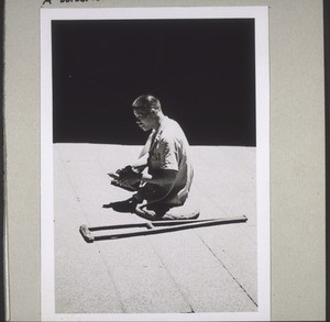 Beggar with the oracle box in the courtyard of a temple