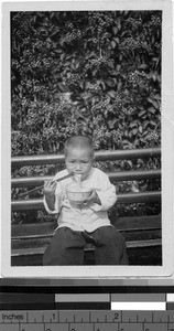 Child eating noodles, Loting, China, 1933