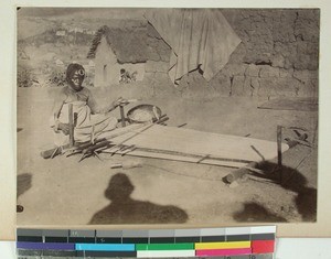 Woman sitting outside her home weaving, Madagascar