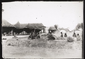 Sokode, Hirsestapel (Sowghumbehälter, davor Frauen mit Stöcken die Hirse zubereitend)