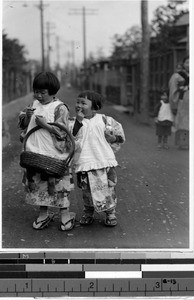 Two young Japanese girls on their way to market, Japan, ca. 1936