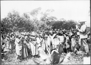 Children looking at a charity box in the shape of an African boy, Tanzania, ca. 1900-1914