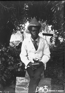 African man sitting on a barrel