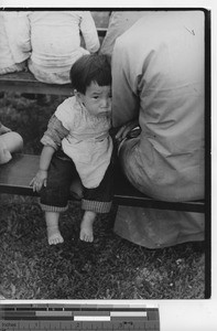 A baby at an outdoor Mass at Fushun, China, 1938