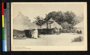 Missionary father standing amid leprosarium huts, Congo, ca.1920-1940