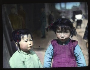 Two young female children standing outdoors, China, ca.1917-1923