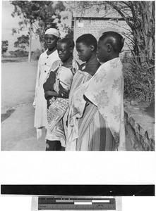 Four women standing in a row outside, Africa, May 1950