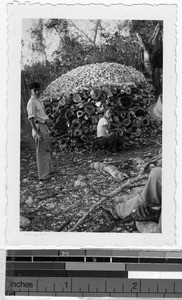 Man crouching in front of a lime kiln, Quintana Roo, Mexico, ca. 1948