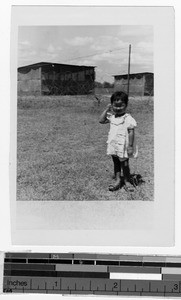 Japanese girl standing in front of a barbed wire fence, Japan, ca. 1946