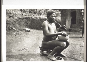 A woman making a pot and smoking a pipe