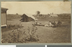 Mr Barlow in the garden with porters, Chogoria, Kenya, ca.1924