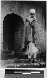 Man standing at the entrance to a stone building, Africa, 1937