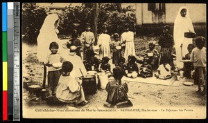 Children eating a meal with missionaries, Bengaluru, India, ca.1920-1940