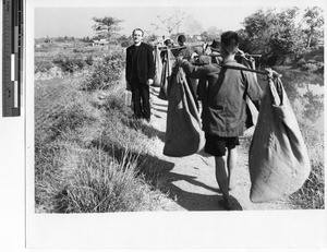 Fr. Meyer walking along the road Jiangmen, China, 1948