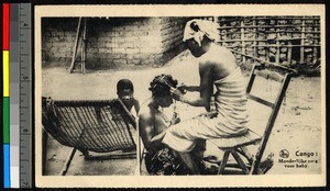 Woman braiding another's hair as a small child looks at the camera, Congo, ca.1920-1940