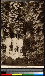 Young men and boys standing and sitting amid thick foliage, India, ca.1920-1940