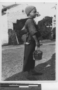 A girl carries a baby at Wuzhou, China, 1934