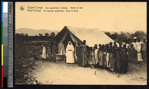 Missionary sister poses with indigenous men and women near a tent, Congo, ca.1900-1930