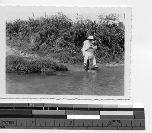 Man carries Fr. Lavin across the river at Luoding, China, 1936