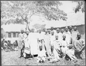 Group of women in front of church and school buildings, Arusha, Tanzania, 1927