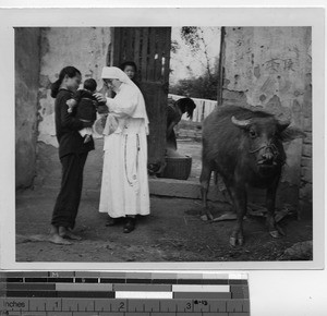 A Maryknoll Sister with a mother and child at Mexien, China, 1940