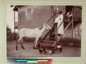 Midonogy Mission Station's courtyard, Alvilde Einrem and her son together with friends on the steps , Midongy, Madagascar, 1901