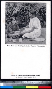 Disabled student and her teacher conducting class on the ground, Pālayankottai, India, ca.1900-1920