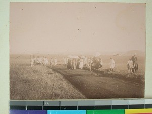 Two horsemen and a group of women walking. Malagasy men and women in the background, Antsirabe, Madagascar, ca.1900