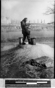 Water carrier at a frozen well, Fushun, China, 1938