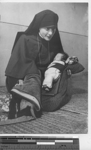 Maryknoll sister with baby at Fushun, China, 1940