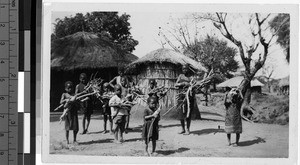 Group of people holding bundles of sticks, Africa, ca. 1920-1940