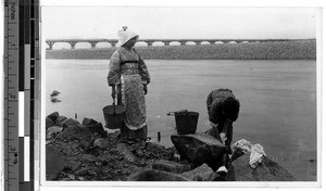 Two women washing clothes in a river, Japan, ca. 1920-1940