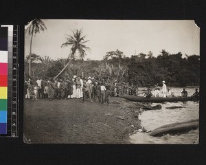 Crowd gathered at shore watching missionary leave, West Africa, 1926