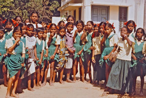 10.- Tamil Nadu, Indien, 1988-89. "Med 80 elever i klassen" - En dansk lærer i Arcot skoleprojekt fortæller: Jeg kom også til at bo tæt ved projektkontoret og tæt på pigerne her. De bor nemlig på Siloam Pigekostskole, en af de to kostskoler, som er med i skoleprojektet. De har lige fået nogle pop-ris, en slags slik, som de er meget glade for, og som vi kan se, de holder i nederdelen foran sig