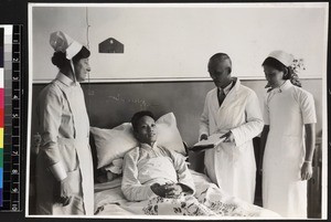 Staff by patient's bedside in hospital ward, Wuhan, China, ca. 1937