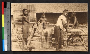 Boys weaving mats outdoors, Congo, ca.1920-1940