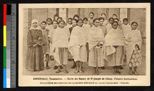 Female students standing with Catholic missionary sister, Madagascar, ca.1920-1940