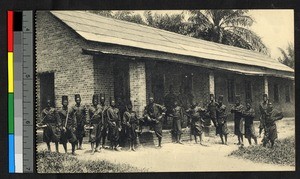 Uniformed school children standing outside a brick building, Congo, ca.1920-1940