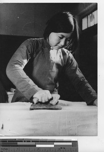 A girl does her chores at Fushun, China, 1939