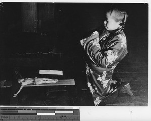 A girl prays on Good Friday at Fushun, China, 1940