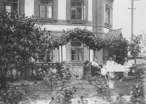 Three women are having coffee under a vine stock - probably in the garden of the missionary hom