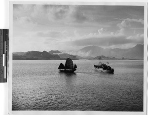 Chinese sailboat and freighter entering Hong Kong harbor, China, 1947