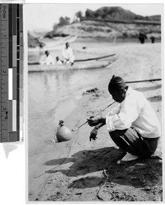 Man smoking by water's edge, Korea, ca. 1920-1940