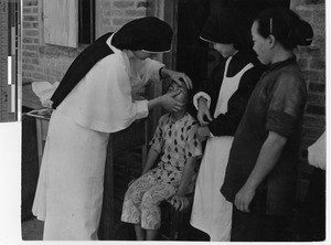 A Maryknoll Sister at dispensary at Taishan, China, 1949