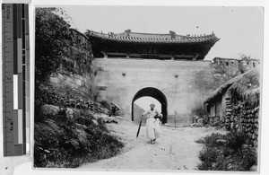 Korean woman passing through a city gate, Korea, ca. 1920-1940